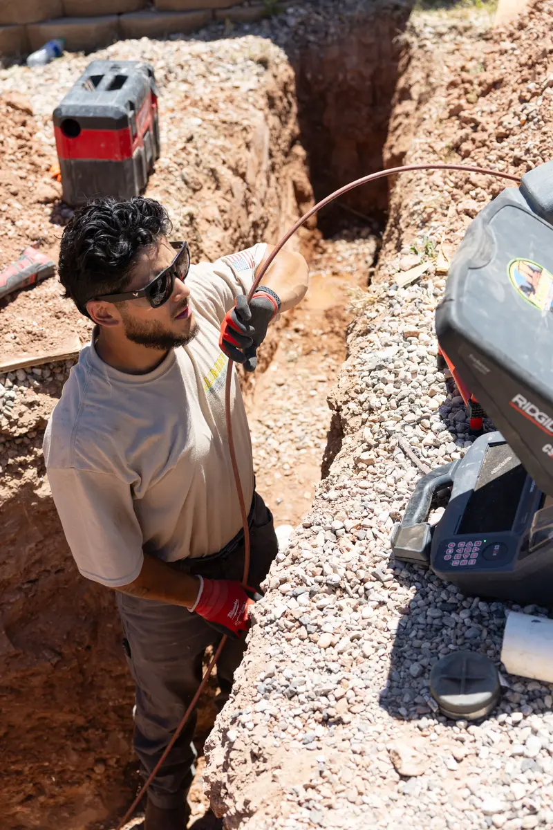Element plumber running a sewer camera in a trench in St. George, UT